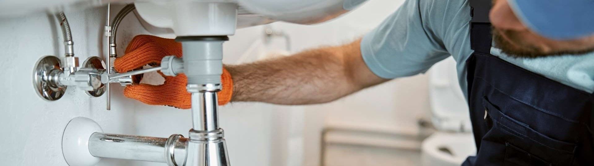 Mitarbeiter repariert ein Waschbecken